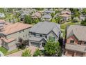 Gorgeous aerial view of a stone-accented home with lush landscaping and a grey tile roof in a lovely neighborhood at 7033 E Lake Cir, Centennial, CO 80111