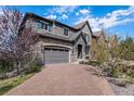 Charming two-story home boasts a brick driveway, stone accents, and a two-car garage at 7033 E Lake Cir, Centennial, CO 80111