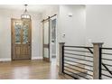 The foyer features wood flooring, with a front door, a sliding door, and a railing leading to the stairs at 7778 Windwood Way, Parker, CO 80134