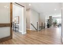 Bright hallway with wood floors, a wood-framed sliding door and a view to the living room at 7778 Windwood Way, Parker, CO 80134