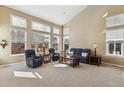 Living room featuring a vaulted ceiling, large windows, plush seating, and ample natural light at 10781 Huntwick St, Highlands Ranch, CO 80130