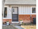 Close-up of the front door with brick trim, plants, and the house number visible at 6880 W Airview Ave, Lakewood, CO 80232