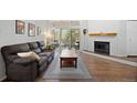 Inviting living room features a cozy fireplace, wood floors, and a sliding glass door to the balcony at 23551 Genesee Village Rd # H, Golden, CO 80401