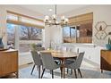 Bright dining room features a round table, elegant chandelier, and large windows with natural light at 2248 S Lincoln St, Denver, CO 80210