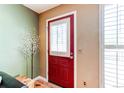 Inviting entryway featuring a vibrant red door, neutral walls, and a view of the window with white blinds at 9565 W Coal Mine Ave # A, Littleton, CO 80123