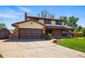 Inviting home exterior showcasing the garage, brick accents, and lush lawn enhancing curb appeal at 1354 S Macon St, Aurora, CO 80012