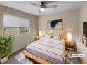 Virtually staged bedroom with neutral tones, wood platform bed, and ceiling fan at 11267 Central Ct, Broomfield, CO 80021