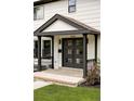 Up close shot of front porch, showing brick stairs, black door, and pillars at 3930 S Hillcrest Dr, Denver, CO 80237