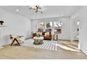 Bright living room featuring large windows, hardwood floors, and modern lighting at 3930 S Hillcrest Dr, Denver, CO 80237