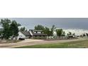 Scenic property with a stone wall, lush greenery, and a long driveway at 22400 County Road 10, Hudson, CO 80642