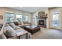 Cozy living room featuring a fireplace, large sectional sofa, and plenty of natural light at 2272 Front Range Rd, Erie, CO 80516