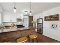 Modern kitchen featuring a breakfast bar, stainless steel appliances, white cabinets and a stylish barn door at 1680 Syracuse St, Denver, CO 80220