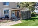 Inviting home with a covered front door, partial privacy fence, and manicured lawn at 8798 Chase Dr # 2, Arvada, CO 80003