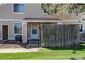 Inviting townhome entrance with a small fenced yard and lush green lawn at 8798 Chase Dr # 2, Arvada, CO 80003