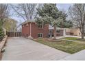 Angle view of brick home with extended driveway and well-maintained lawn at 6970 Upham St, Arvada, CO 80003