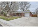 Beautiful brick home with an attached garage and a manicured lawn at 6970 Upham St, Arvada, CO 80003