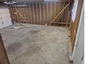 Unfinished two car garage with concrete slab and exposed wood stud framing at 17900 E Asbury Dr, Aurora, CO 80013