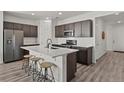 Contemporary kitchen with a large island, dark cabinetry, stainless steel appliances, and a sleek, modern design at 16099 Alberta Dr, Parker, CO 80134