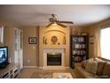 Cozy living room featuring a fireplace, ceiling fan, and a comfortable seating area with natural light at 9926 Apollo Bay Way, Highlands Ranch, CO 80130