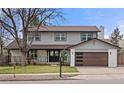 Inviting home features a modern garage door, covered porch, and fresh landscaping at 4102 W Union Ave, Denver, CO 80236