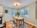 Bright dining room featuring hardwood floors, large windows, and a modern light fixture at 4844 Vallejo St, Denver, CO 80221