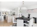 Bright and airy dining room featuring a round table with modern chandelier and white chairs at 421 S Pearl St, Denver, CO 80209