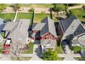 Aerial view of a red two-story home with a well-maintained backyard and a gray shingle roof at 10778 Dayton Way, Commerce City, CO 80640