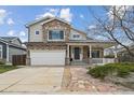 Charming two-story home featuring a stone facade, covered porch, and well-maintained front yard at 5986 Dunraven Ct, Golden, CO 80403
