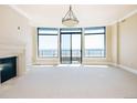 Open living room featuring a modern fireplace and a wall of windows with captivating city views and natural light at 8100 E Union Ave # 2201, Denver, CO 80237
