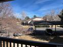 Balcony view overlooking parking area, neighboring buildings, and mature trees under a blue sky at 9262 E Arbor Cir # H, Englewood, CO 80111