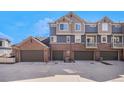Exterior view of townhome garages with ample parking space on a sunny day at 755 Roslyn St # 17, Denver, CO 80230