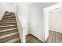 Bright hallway featuring neutral tones, carpeted stairs, and wood-look vinyl flooring at 755 Roslyn St # 17, Denver, CO 80230