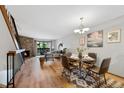 Inviting living room featuring a stone fireplace, wood floors, and a dining area adjacent to a large window at 451 Wright St # 11, Lakewood, CO 80228