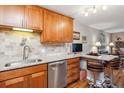 Kitchen features wood cabinets, stainless steel appliances, granite countertops, and breakfast bar with chairs at 9320 E Center Ave # 7A, Denver, CO 80247