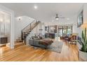 Inviting living room features hardwood floors, a staircase with black metal railing, and an open-concept design at 2420 S Gilpin St, Denver, CO 80210