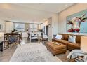 Open-concept living room and kitchen with modern decor, wood floors, and ample natural light at 9023 E Northfield Blvd, Denver, CO 80238