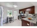 Modern kitchen featuring granite countertops, stainless steel appliances, and rich wood cabinetry at 4812 W 8Th Ave, Denver, CO 80204