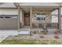 Charming, covered front porch with stone accents and a relaxing seating area at 4815 Cattle Cross Rd, Castle Rock, CO 80104