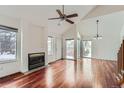 Bright living room featuring hardwood floors, a fireplace, and vaulted ceilings at 2121 S Troy Way, Aurora, CO 80014
