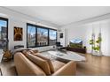 Modern living room with large windows showcasing a city view, hardwood floors, and contemporary decor at 1750 Wewatta St # 700, Denver, CO 80202