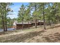 A view of the home with stone accents from the side, showing driveway access to the garage at 2857 Hiwan Dr, Evergreen, CO 80439