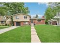 Inviting front exterior showcasing a well-maintained lawn, brick details, and a tidy landscape at 6320 E Asbury Ave, Denver, CO 80224