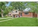 Attractive home with a brick and siding exterior, complemented by a green lawn at 6320 E Asbury Ave, Denver, CO 80224