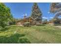 Expansive backyard featuring lush green lawn, mature trees, and a tranquil setting, ideal for outdoor enjoyment at 8164 Flower Cir, Arvada, CO 80005