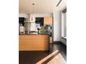 Modern kitchen featuring stainless appliances, black countertops and a wood island at 1133 14Th St # 1820, Denver, CO 80202