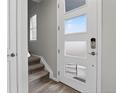Bright entryway with a modern front door, wood floors, and stairs to the upper level at 19629 W 93Rd Dr # C, Arvada, CO 80007