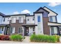 Stylish townhome featuring a mix of brick and siding, with a cozy front porch at 19629 W 93Rd Dr # C, Arvada, CO 80007