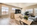 Bright living room featuring wood floors, neutral walls, large windows, and modern furniture at 12708 Tamarac St, Thornton, CO 80602