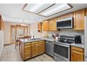 Well-equipped kitchen with stainless steel appliances and wood cabinets at 7624 S Cove Cir, Centennial, CO 80122