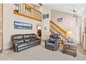 Spacious living room featuring a cozy leather sofa, lofted ceilings, and ample natural light at 7624 S Cove Cir, Centennial, CO 80122